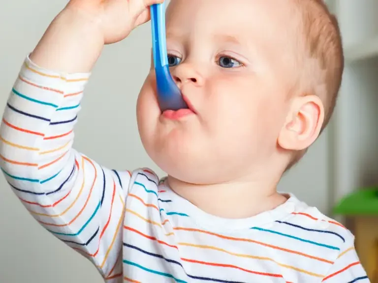 Baby isst mit einem Löffel